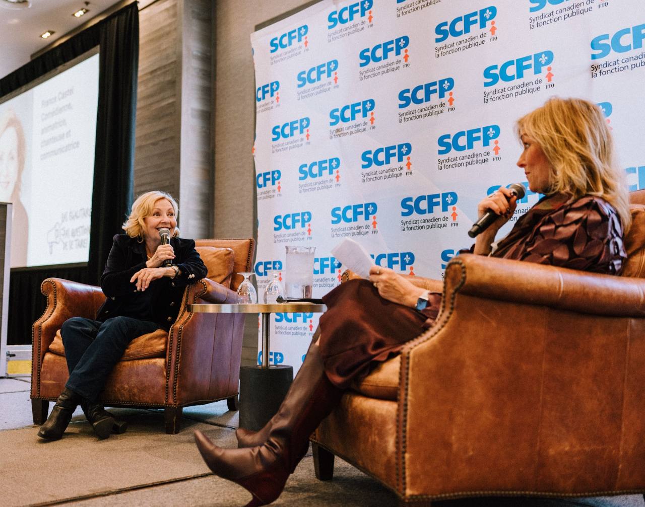 Deux intervenantes échangent au microphone sur scène lors du colloque.